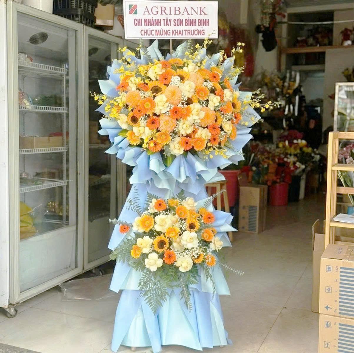 Kệ Hoa Mừng Khai Trương 2 Tầng Tone Cam Hoa Hướng Dương Mix Đồng Tiền