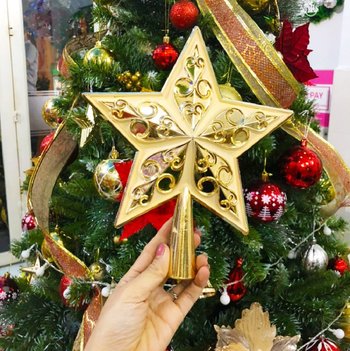 Ngôi sao đỉnh vàng trang trí trên cây thông noel