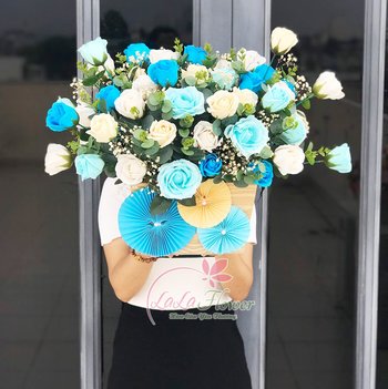 Lẵng hoa hồng sáp để bàn trắng và xanh