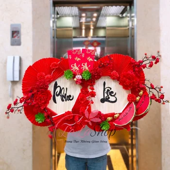 An Tet-Feiertagen hüllt Phat Loc rote Glücksgeldumschläge ein, um Tet-Miniaturen zu dekorieren